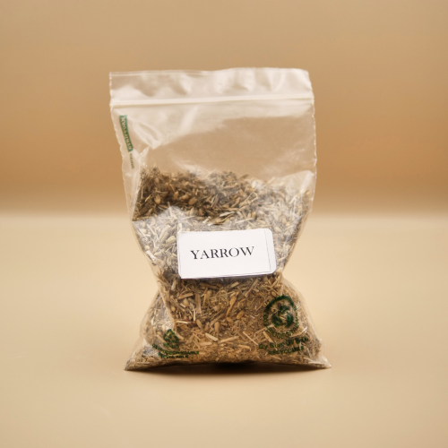 Bag of yarrow herb with a label on a beige background