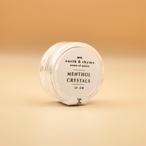 Jar of menthol crystals with 'earth & thyme' branding on a beige background