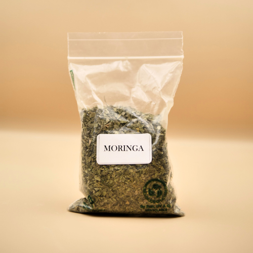 Bag of Moringa leaves with a label on a beige background