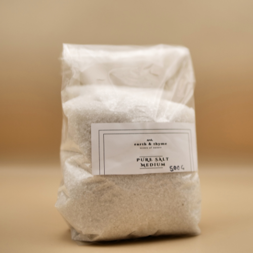 Bag of pure salt labeled 'earth & thyme' on a beige background