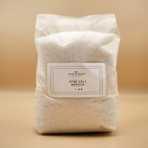 Bag of pure salt labeled 'earth & thyme' on a beige background